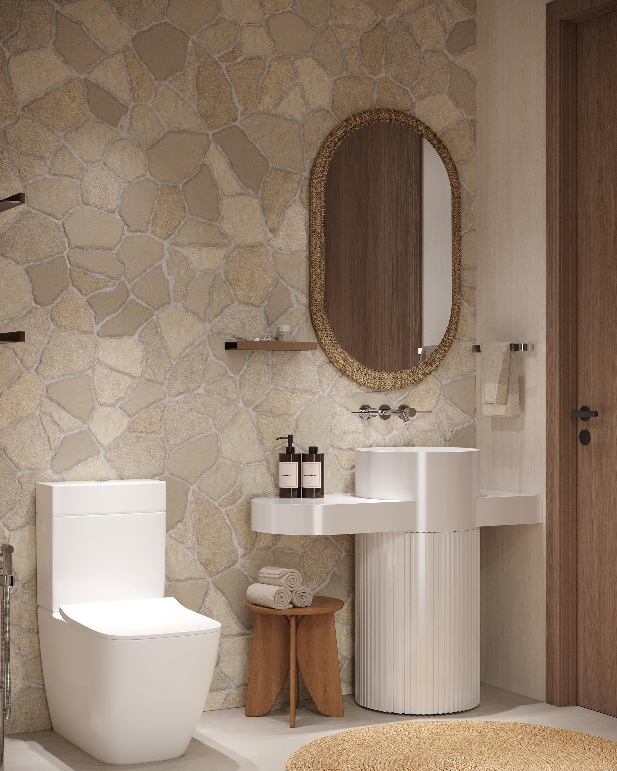 IO Villas — Bathroom 2: natural stone mosaic feature wall, fluted pedestal sink and woven mirror