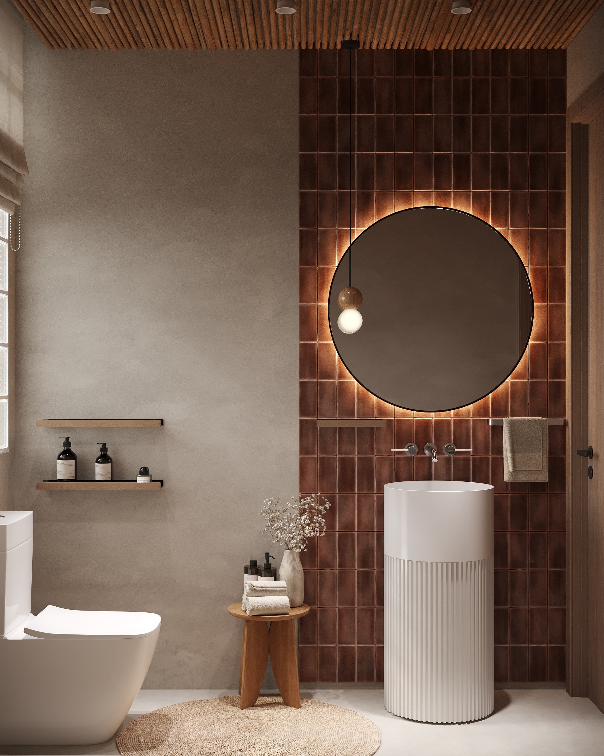 IO Villas — Guest Bathroom: terracotta tile feature wall with backlit round mirror and fluted pedestal sink